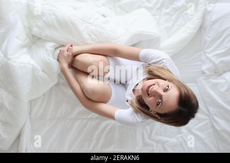Young woman in pajamas in bed top view Stock Photo
