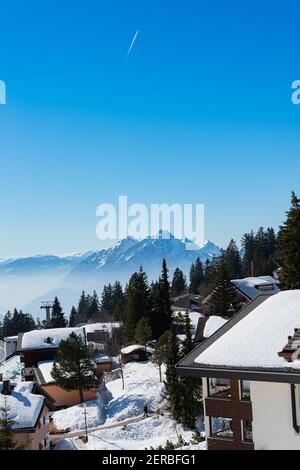 Unique panoramic alpine skyline view of Rigi resort. Snowed Chalets, wooden lodging cabins, hotels, mount Pilatus, blue sky. Mount Rigi, Weggis, Lucer Stock Photo