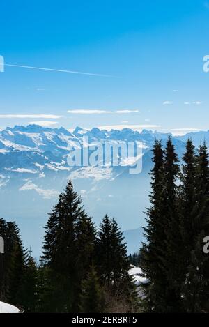 Unique panoramic alpine skyline aerial landscape view of misty iced Swiss Alps peaks in blue sky. Mount Rigi Switzerland in spring. Travel concept.
