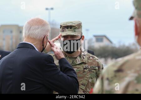 President Joe Biden returns a salute as he walks to speak during a ...