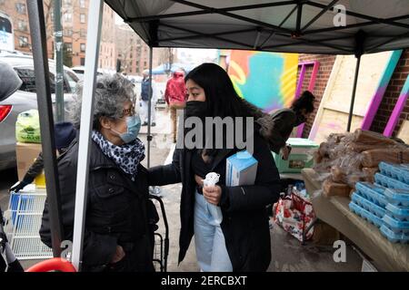 New York, New York, USA. 28th Feb, 2021. SANDRA PEREZ, left of the Quuensbridge community talks with community organizer GRACE FRUTOS during the reopening of the Queensbridge community Fridge on 40th Avenue in New York. Over 500 pounds of food, clothing and perishables were donated. Frutos said 'this new fridge is vegetarian, loaded with fruits and vegetables and we're hopping it will promote healthier life style and healthier food for the community. 'Once this fridge is appropriate by the community we're hoping to build a second fridge. (Credit Image: © Brian Branch Price/ZUMA W Stock Photo