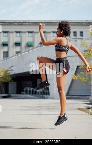 Strong athletic afro woman running over black background Stock