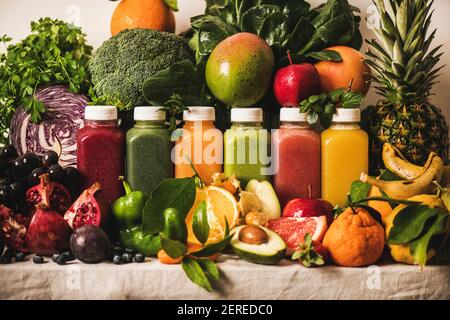 Various fresh smoothies for detox weight loss diet program. Colorful juices in vacuum bottles with fruit, vegetables and greens around, white backgrou Stock Photo