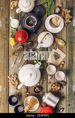 Various tea and teapots composition, dried herbal, green, black tea and matcha tea on wooden table background, flat lay Stock Photo