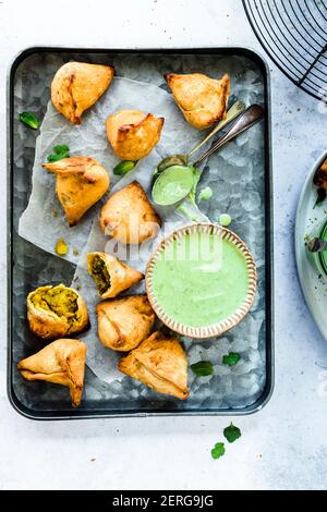 Samosa served with Yogurt Mint Sauce on rectangle serving tray Stock Photo