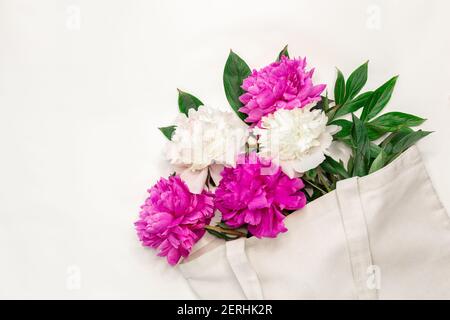 Cotton eco bag with peony flowers on white background Zero waste concept. Flat lay. Top view - Image Stock Photo