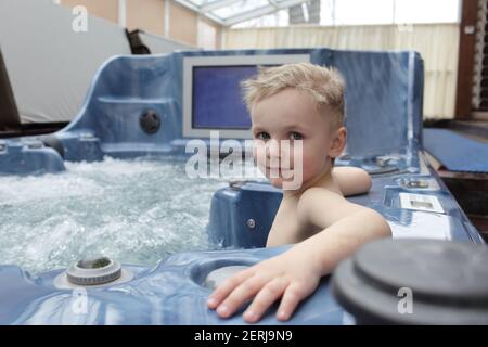 Child sitting in the warm bubbling water jacuzzi Stock Photo