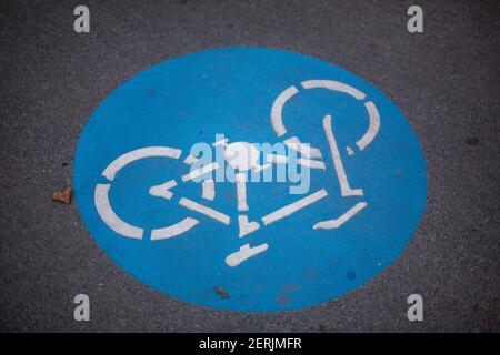 An upside down blue textured bicycle lane sign on the pavement inVienna, Austria. Stock Photo