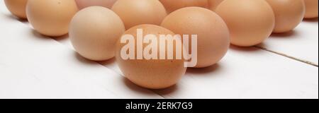 chicken eggs laid out in even rows on a white wooden table Stock Photo