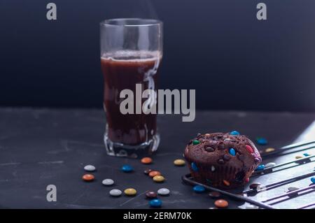 Chocolate muffin and cocoa in a glass. Snack with muffins and cocoa. Stock Photo