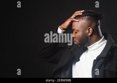 Black man in profile with hand on forehead. Stock Photo