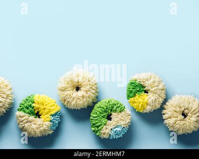 Shag donuts on blue background. Unusual trendy colorful donuts with vanilla buttercream. Copy space. Top view or flat lay. Stock Photo