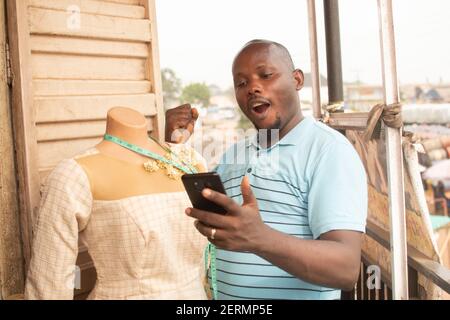 a man holding his phone and expressing himself Stock Photo