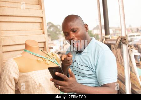 a man holding his phone and expressing himself Stock Photo