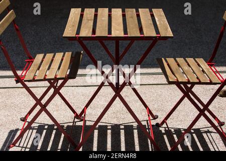 Sleek wooden table and chairs at an outdoor cafe setting. Stock Photo