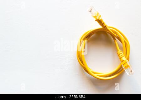 yellow lan internet cable on a white background with space for text Stock Photo