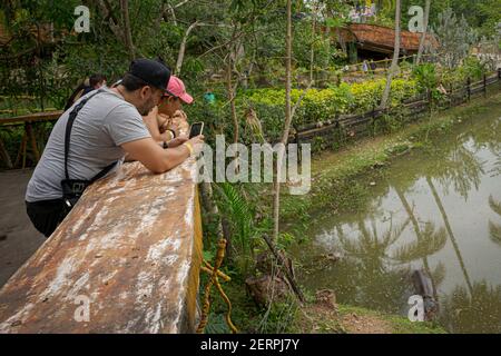 Puerto Triunfo, Colombia. 18th Feb, 2021. Tourists take photos of Vanessa, the only hippo that has a tamed pond at the 'Hacienda Nápoles'. The hippos, which the drug lord Pablo Escobar once brought to Colombia, have multiplied so much that the country is looking for a solution for the animals. Credit: Luis Bernardo Cano/dpa/Alamy Live News Stock Photo