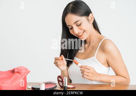 beauty face of asian woman. portrait of female applying lipstick on her face close up Stock Photo