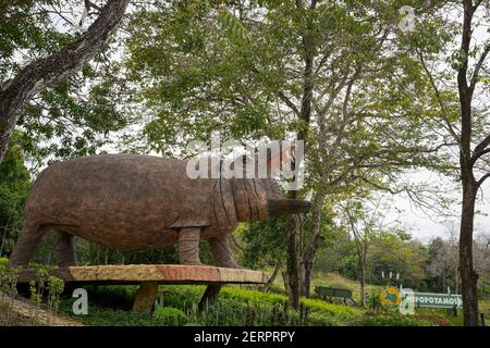 Puerto Triunfo, Colombia. 18th Feb, 2021. A hippo statue and a sign indicate where hippos can be observed within the 'Hacienda Nápoles'. The hippos, which the drug lord Pablo Escobar once brought to Colombia, have multiplied so much that the country is looking for a solution for the animals. Credit: Luis Bernardo Cano/dpa/Alamy Live News Stock Photo