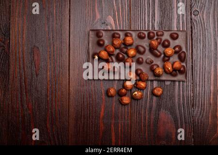 Dark chocolate with hazelnuts on wooden background Stock Photo