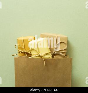 Yellow gift boxes in shopping bag on green background. top view, copy space Stock Photo