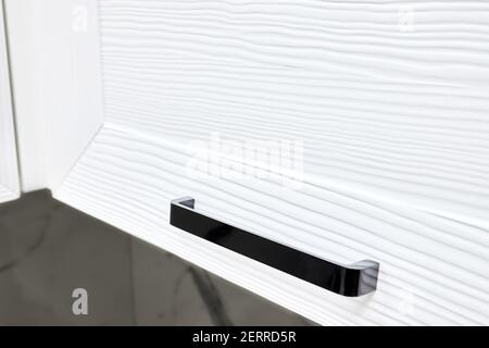 Concept of home kitchen storage organized cabinetry drawer or cupboard door handle furniture. Steel rectangular black knob selective focuse on brushed Stock Photo