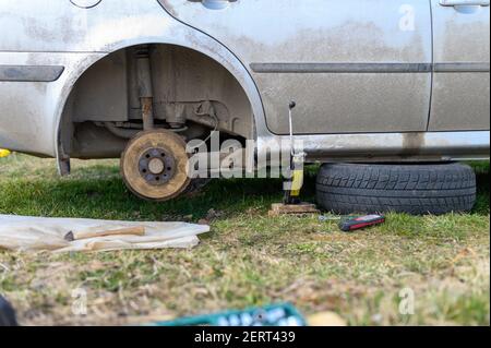 own repair of car drum brake himself. repair of broken car drum brake disassembled outdoor Stock Photo