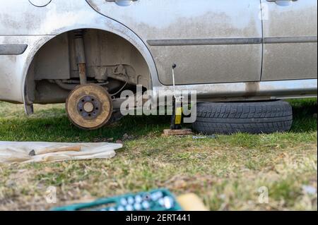 own repair of car drum brake himself. repair of broken car drum brake disassembled outdoor Stock Photo