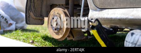 own repair of car drum brake himself. repair of broken car drum brake disassembled outdoor. banner Stock Photo