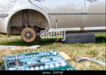 own repair of car drum brake himself. repair of broken car drum brake disassembled outdoor Stock Photo