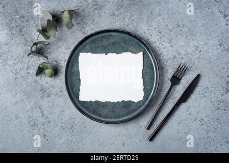 An empty plate and cutlery on a gray table. Stock Photo