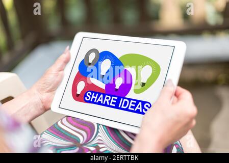 Share ideas concept shown on a tablet held by a woman Stock Photo
