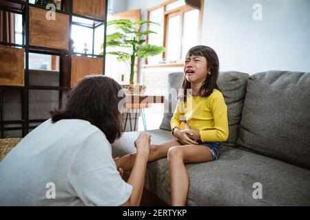 asian mother treating injured daughter with antiseptic at home Stock Photo