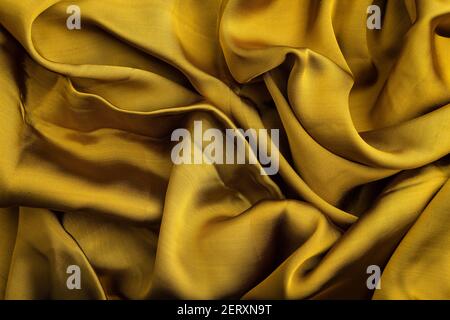 Fragment of yellow and green tissue. Side view, synthetic textile background and texture. wave concept, abstract. Stock Photo