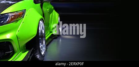 Front headlights of green modify car on black background, copy space Stock Photo