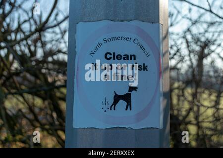 A close up view of a it up or risk a fine sticker on a lamp post near a park Stock Photo