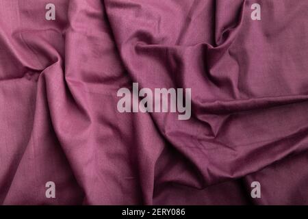 Fragment of cotton purple tissue. Top view, natural textile background and texture. wave concept, abstract. Stock Photo