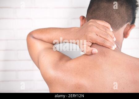 man suffering from neck pain at home. Stock Photo