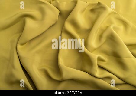 Fragment of green olive silk tissue. Top view, natural textile background and texture. wave concept, abstract. Stock Photo