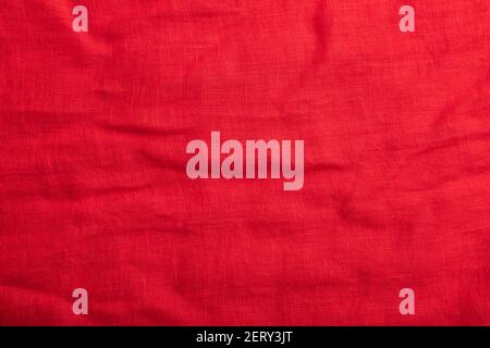 Fragment of smooth red linen tissue. Top view, flat lay, natural textile background and texture. Stock Photo