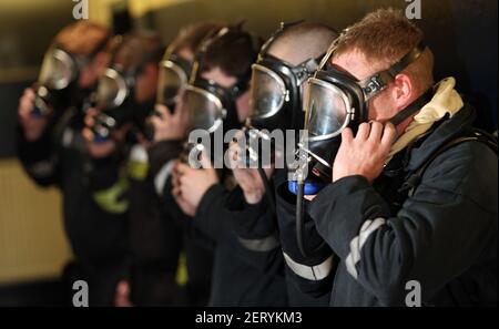 Fire trainees trying out breathing apparatus masks Stock Photo