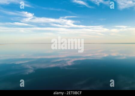Salt lake water under blue sky with fluffy clouds in summer day. Creative color concept