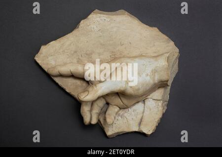 plaster cast of pointing finger hand on brown wall background Stock Photo