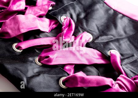 Pink Cord In Fashionable Black Lace Up Dress, macro. Background Stock Photo