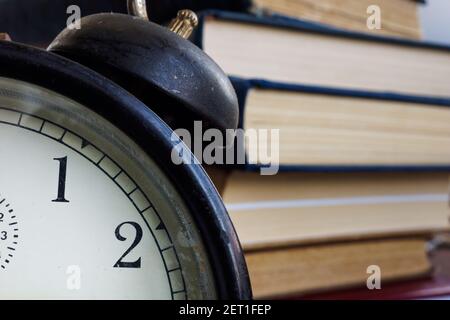 Time to learn concept. Close up of alarm clock and book. Stock Photo