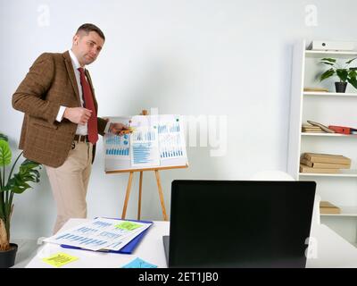 A man in a suit makes an online presentation with laptop. Stock Photo