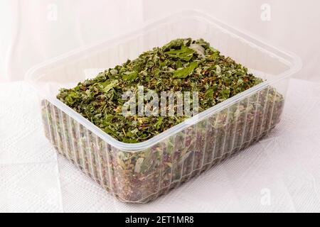 Dried mint lemon balm with herbal tea in a plastic container. Stock Photo