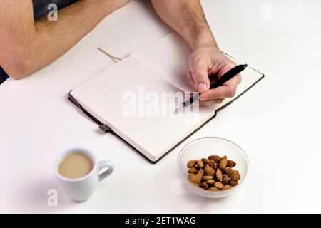 Close up of man writing on a notebook. Stock Photo