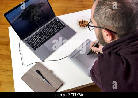Back view of man using graphic tablet and pen. Stock Photo