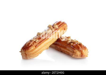Caramel eclairs sprinkled with gold isolated on white background. French sweet dessert. Stock Photo